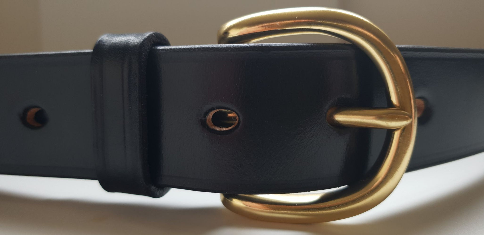 Polished edge of black bridle leather belt
